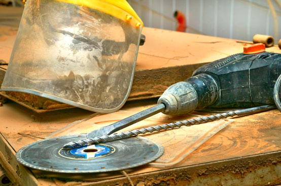 Dusty drill, saw blade, safety visor.