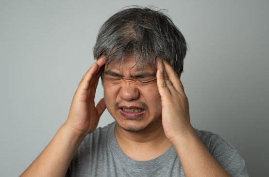 Person with headaches, gray shirt