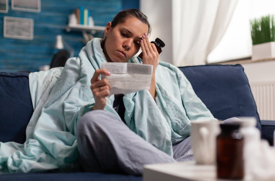 Person reading paper on couch, felling seeks