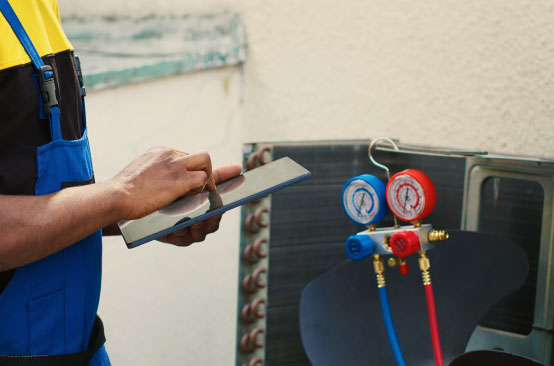 Technician checking HVAC system pressure gauges.