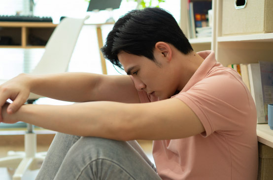 Person sitting on floor, head down