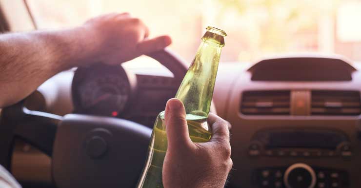 Suspected drunk driver with open beer in vehicle crashes into light pole