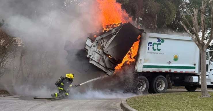 Rear gate jams on burning garbage truck, tow rig helps firefighters pry it open