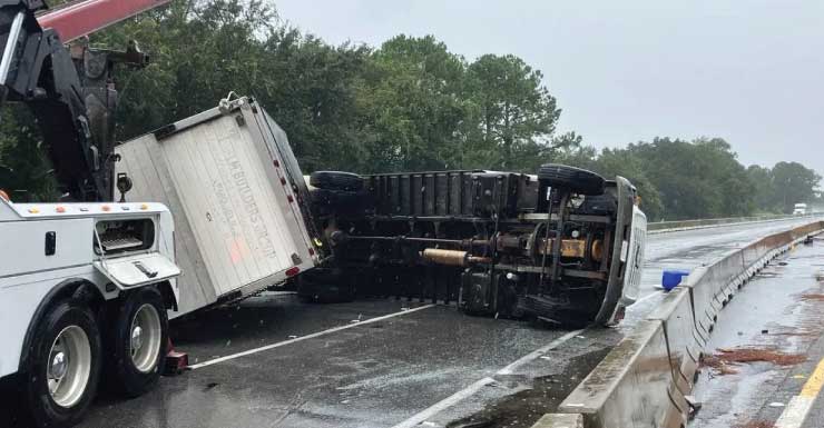 Tractor trailer towing a truck overturns on I-10 in Escambia County